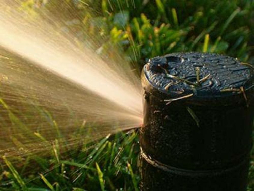 A repaired rotor head spraying a clean arc of water in warm light