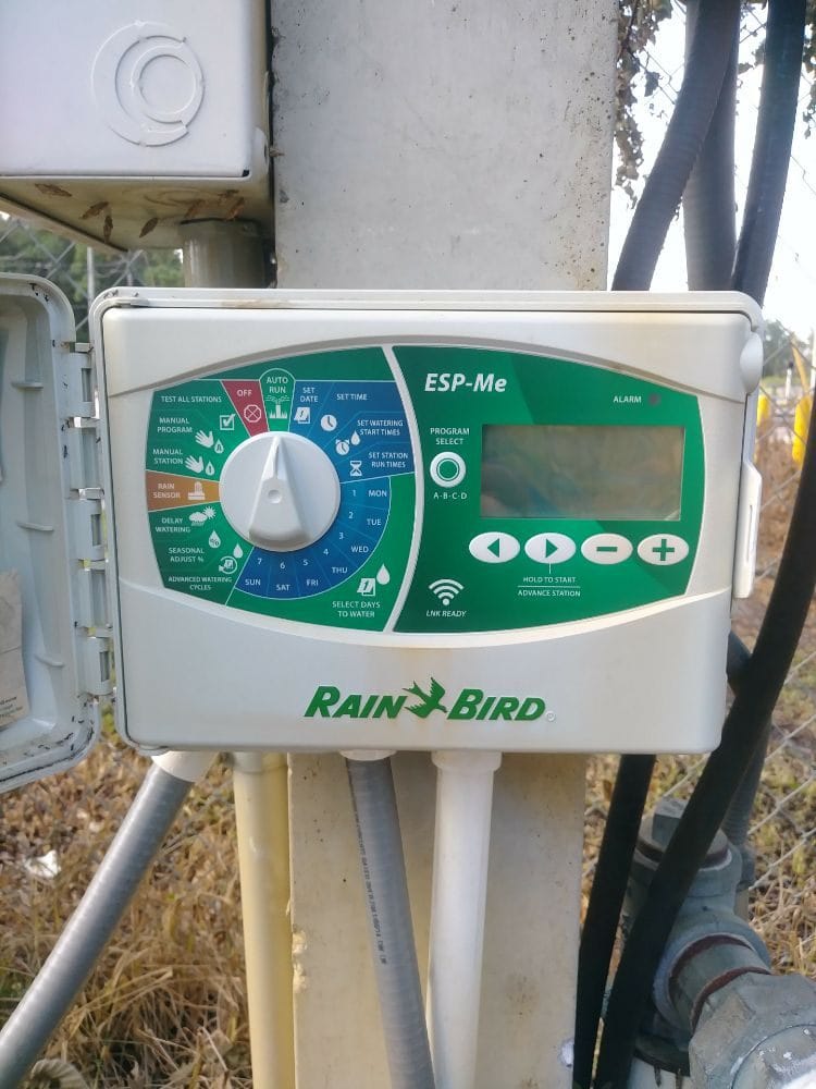 A mounted Rain Bird ESP-Me irrigation timer with wiring